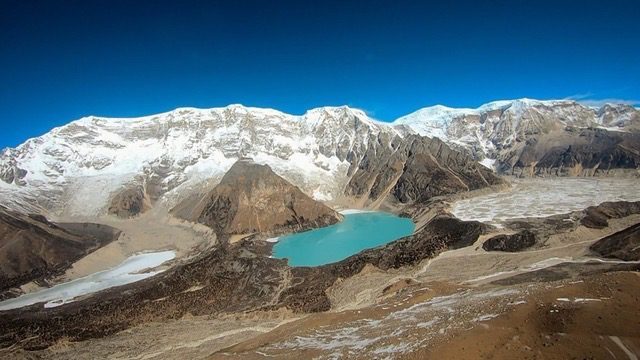 A turquoise glacial lake below the snowline in Bhutan