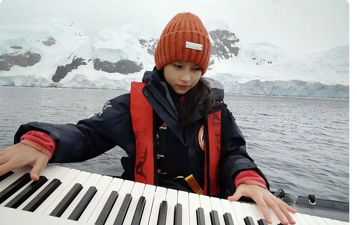 Hillary O’Sullivan playing a keyboard on the water in Antarctica, from the South China Morning Post Young Post feature